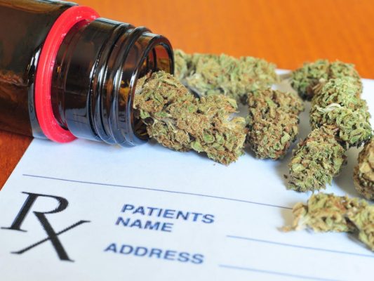Cannabis flower over a prescription pad.